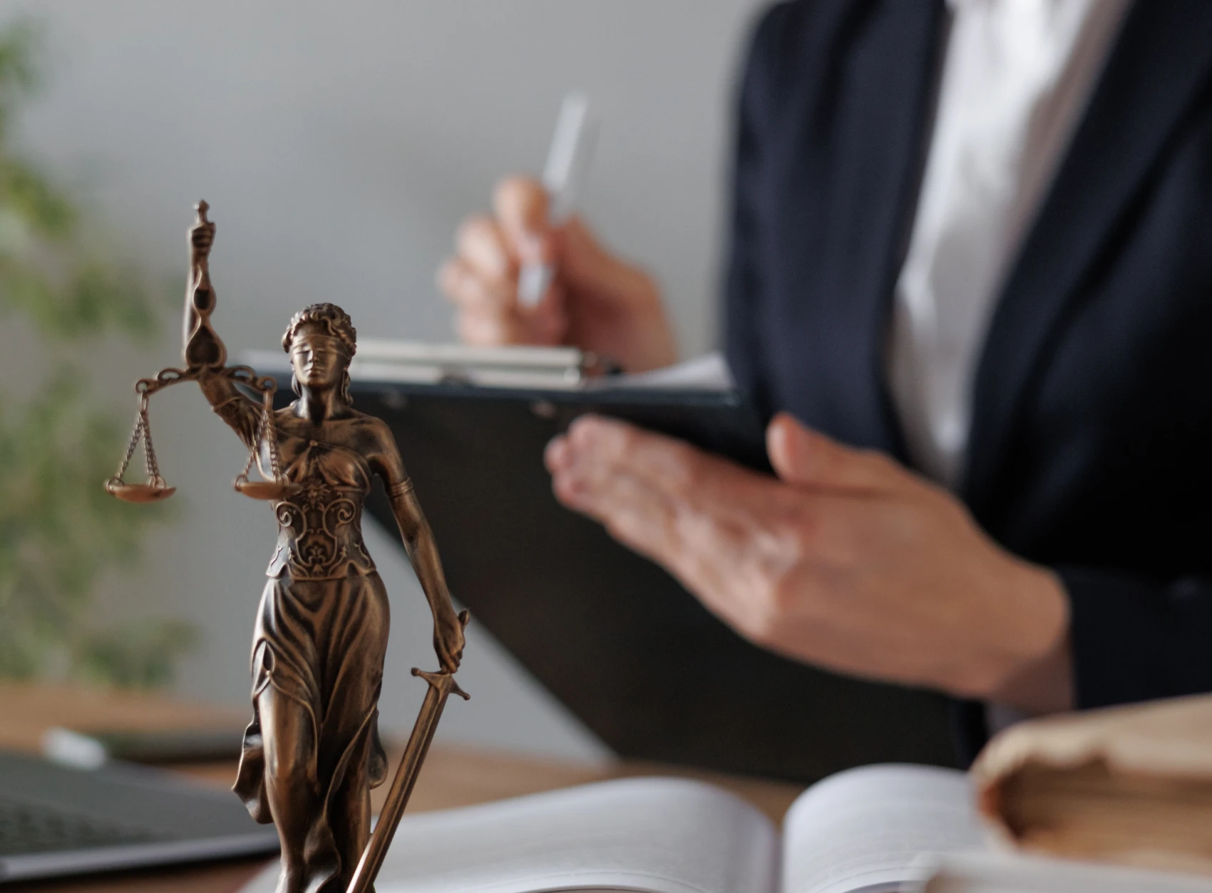 Lady Justice statue and person writing